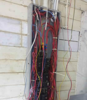 An electrical distribution panel with bad, unsafe wiring.